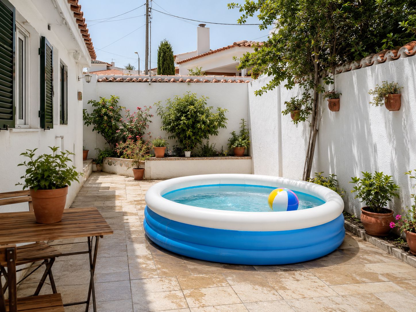 Piscina insuflável redonda montada num pátio pequeno, mostrando uma solução simples e proporcional para refrescar a casa sem ocupar espaço em excesso.