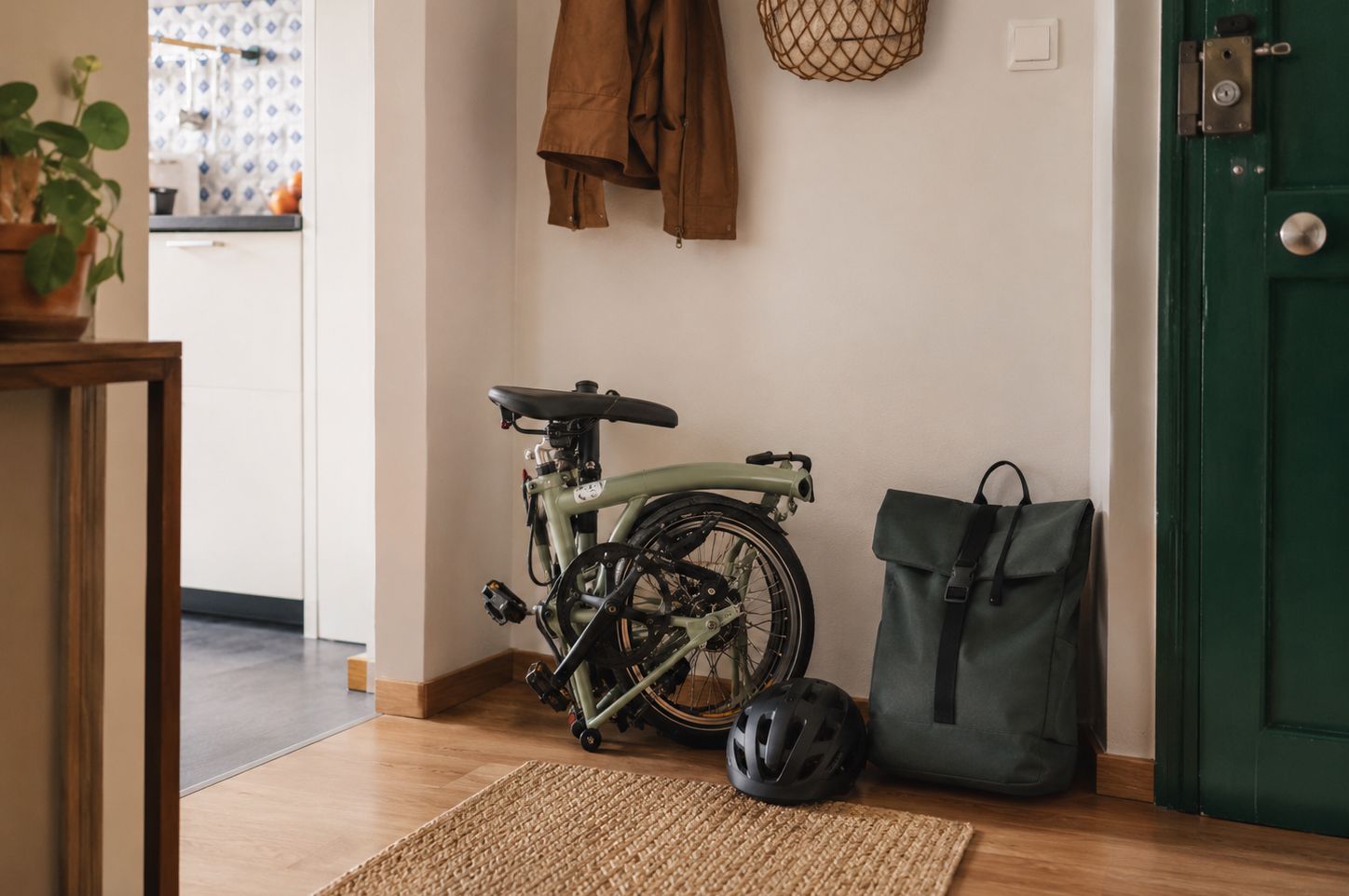 Bicicleta dobrável fechada junto à entrada de um apartamento, mostrando uma solução prática para quem tem pouco espaço em casa.
