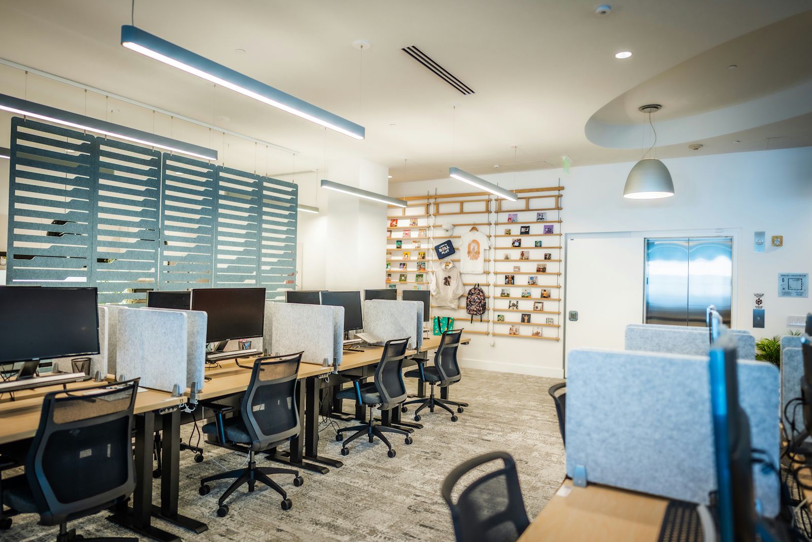 Escritório moderno e luminoso, com secretárias, computadores e cadeiras, organizado para um ambiente de trabalho eficiente